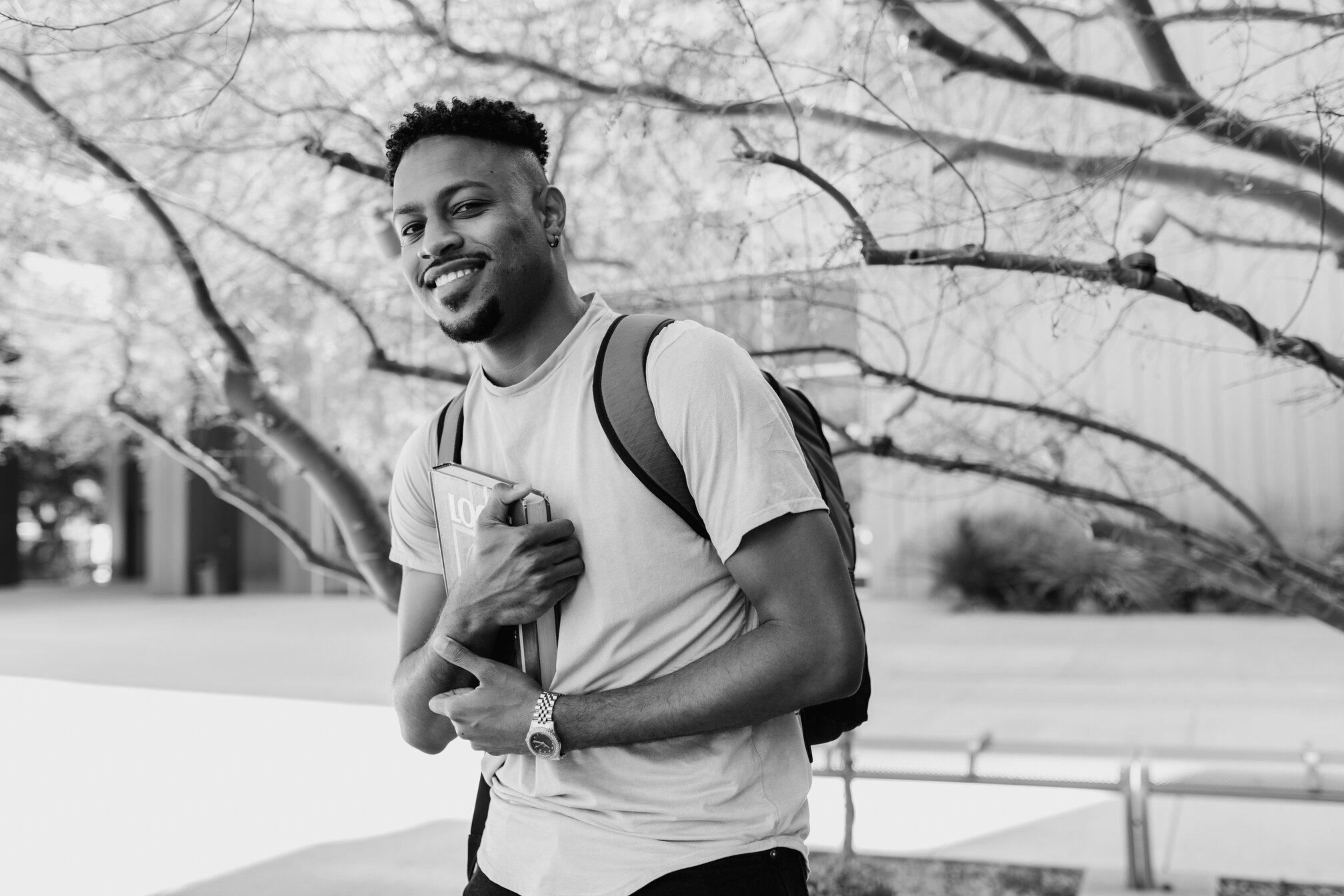 A College Student Holding a Book and Smiling